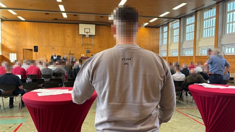 Ein Häftling der JVA Frankenthal von hinten in einer Turnhalle, Abschied von Gefängnispastor Manfred Heitz in der JVA Frankenthal