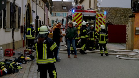 Anwohner und Einsatzkräfte in Kallstdt. Wegen des Brandes musste die Straße vor dem Weingut stundenlang gesperrt werden.
