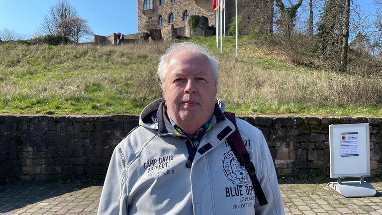 Harald Sattler aus Dietzenbach bei Frankfurt am Fuß des Hambacher Schlosses. Er hat das Schloss schon öfter gesehen und interessiert sich für das Hambacher Fest von 1832. Er freut sich, dass der Tag der Demokratiegeschichte auf den Tag seines Besuches gefallen ist.
