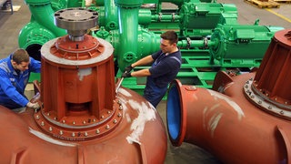 Zwei Industriemechaniker arbeiten in einem KSB-Werk an einer Pumpe: Der Pumpen- und Armaturenhersteller aus Frankenthal hat 2025 mehr als drei Milliarden Euro Umsatz gemacht.