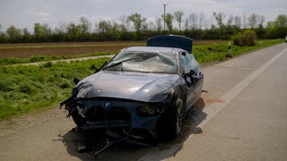 Das Bild zeigt ein zerstörtes Auto am Rand der Autobahn. Das Fahrzeug hatte sich auf der A65 bei Haßloch mehrfach überschlagen. Beide Insassen wurden schwer verletzt.