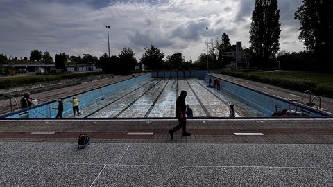 Ehrenamtliche putzen ein Schwimmbecken im Hambacher Freibad (Archivbild)