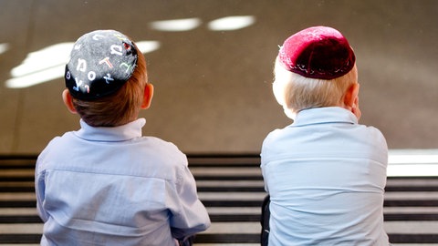 Zwei jüdische Jungen mit Kippa sitzen nebeneinander (Symbolbild)