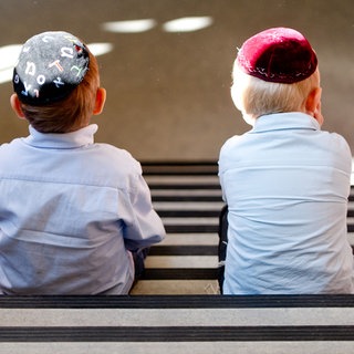 Zwei jüdische Jungen mit Kippa sitzen nebeneinander (Symbolbild)