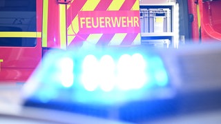 Feuerwehrwagen steht hinter einen Blaulicht - bei einem Brand eines Wohnhauses in Herxheim bei Landau ist ein Mann ums Leben gekommen