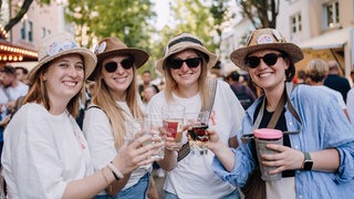 Besucherinnen mit Schorle und Strohhüten auf dem Strohhutfest in Frankenthal
