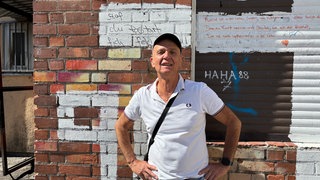Robert Azari vor einer roten Wand in der Bayreuther Straße.