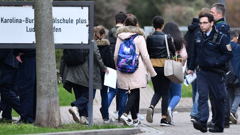 Schüler verlassen im Jahr 2018 unter Polizeischutz die Karolina-Burger-Realschule plus.