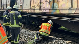 Feuerwehrleute überprüfen im Rheingau die Bremsen eines Güterzuges, nachdem er mehrere Brände verursacht hat.