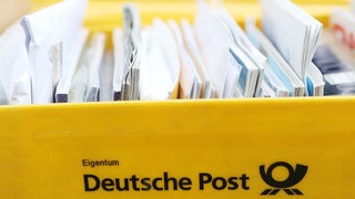 Briefe liegen in einer gelben Postbox.