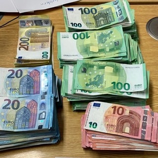 Auf einem Tisch liegen 83 900 Euro Bargeld in Scheinen, die die Polizei beschlagnahmt hat. Das Foto ist ein Symbolbild.