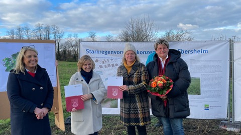 Umweltministerin Katrin Eder übergibt der Mainzer Umweltdezernentin Janina Steinkrüger den Förderbescheid für die Starkregenmassnahmen.