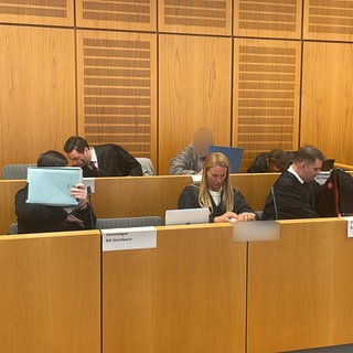 Auf der Anklagebank im Landgericht Mainz sitzen zwei Angeklagte und vier Verteidiger.
