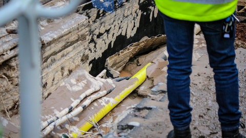 Ein Mitarbeiter der Mainzer Netze steht vor der Stelle, an der die Schillerstraße in Mainz durch einen Wasserrohrbruch unterspült wurde.