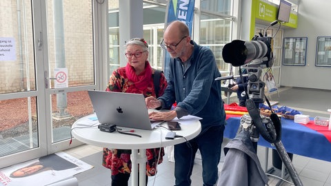 Der Fotograf Thomas Brenner bei der Plakataktion für Demokratie an der TH Bingen neben einer Frau, die er fotografiert hat.