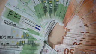 Auf einem Tisch liegen falsche 50- und 100-Euro-Scheine. 20.000 Euro Falschgeld hat jetzt die Polizei u.a. in Bad Kreuznach gefunden.