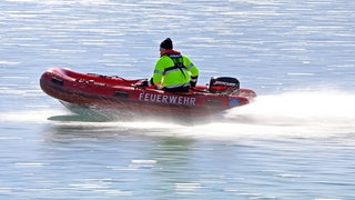 Ein Feuerwehrboot mit einem Mann im Einsatz