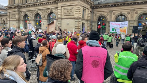 Demonstranten mit Fahnen und Plakaten beim Klimastreik vor Bundestagswahl in Mainz am Hauptbahnhof