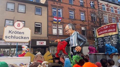 Motivwagen "Kröten schlucken" beim Rosenmontagszug in Mainz.