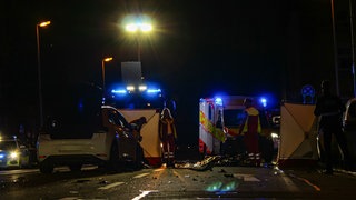 Das kaputte Unfallauto steht auf der Kreuzung in der Nähe eines Mainzer Hotels. Rettungskräfte sind im Einsatz.