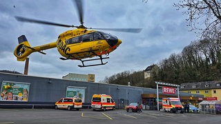 Ein Rettungshubschrauber schwebt über einem Supermarktparkplatz in Kirn. Dort ist eine Frau von einer Autofahrerin überrollt worden