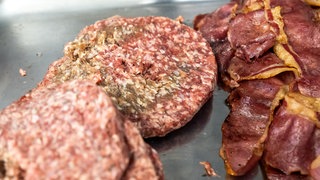 Ungekühltes Fleisch mit Verfärbungen liegt auf einem Blech.