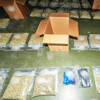 Drogen liegen in Klarsichtbeuteln auf dem Boden: Bei umfangreichen Durchsuchungen wurden dutzende Kilogramm Betäubungsmittel sichergestellt.