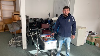 Maxim Juschak, Vorsitzender der Ukraine-Hilfe Worms, mit einem Teil der Sachspenden. Hinter ihm stehen die Rollatoren für schwerverletzte Soldaten.