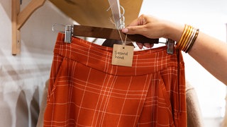 Ein roter Rock mit einem Schild "Second Hand": In Mainz wollen die Macher der Fashion Revolution Week den Menschen nachhaltige Mode näher bringen. 