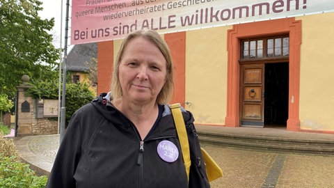 Andrea Keber von der Bewegung Maria 2.0 steht in Nieder-Olm vor der katholischen Kirche St. Georg.