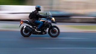 Ein Motorradfahrer auf einer Straße - in Mainz hat ein Mann auf einem Motorrad Leute überfallen. (Symbolbild)