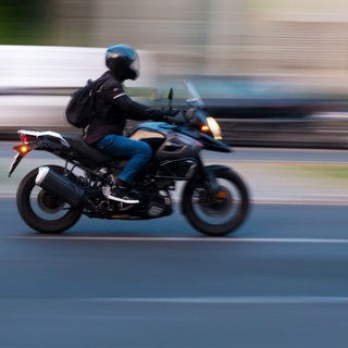 Ein Motorradfahrer auf einer Straße - in Mainz hat ein Mann auf einem Motorrad Leute überfallen. (Symbolbild)