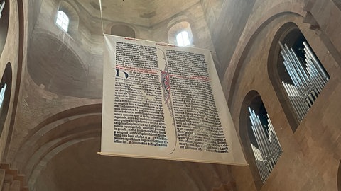 Die Riesen-Bibelseite hängt im Ostchor des Mainzer Doms.