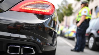 Eine Polizistin kontrolliert ein getunte Auto. Die Polizei hat in Bingen dutzende Autos aus dem Verkehr gezogen.