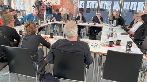 Die Schauspieler der Nibelungen-Festpiele sitzen an einem Tisch zur ersten Leseprobe. 