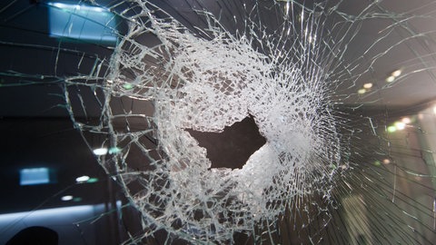 Eine gesplitterte Glasscheibe mit einem Loch. Unbekannte haben in Nierstein das künftige Bürgerbüro der AfD beschädigt (Symbolbild)
