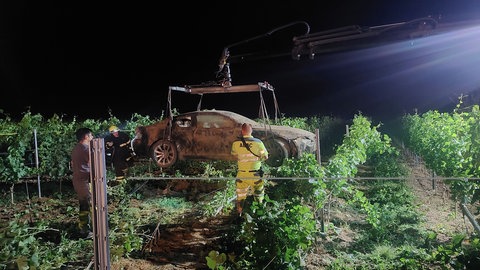 Ein Auto hängt am Kran eines Abschleppwagens. Es war bei Bad Kreuznach in einem Weinberg gelandet