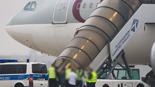 Polizei und andere Personen vor einem Flugzeug der Qatar Airways am Flughafen Halle-Leipzig. Mit dem Flugzeug wurden 81 Menschen nach Afghanistan abgeschoben, darunter auch ein aggressiver Flüchtling aus Windesheim