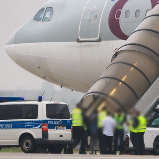 Polizei und andere Personen vor einem Flugzeug der Qatar Airways am Flughafen Halle-Leipzig. Mit dem Flugzeug wurden 81 Menschen nach Afghanistan abgeschoben, darunter auch ein aggressiver Flüchtling aus Windesheim