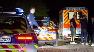 Auf einem Feldweg in Sulzbach in Rheinhessen stehen zwei Polizeifahrzeuge und ein Rettunsgwagen.