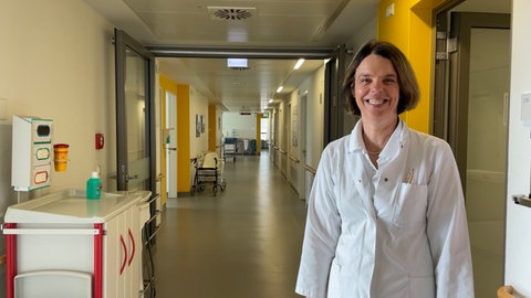 Dr. Ulrike Buchwald steht auf einem Gang in einem Krankenhaus.