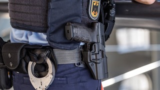 Ein Polizist mit Handschellen und Waffe