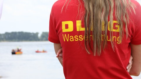 Eine Mitarbeitern der DLRG beobachtet eine Rettungsaktion im Rhein.