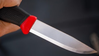 Nahaufnahme von einem Messer in der Hand eines Mannes (Symbolbild). In Mainz hat ein Jugendlicher einen Schüler mit einem Messer bedroht. 