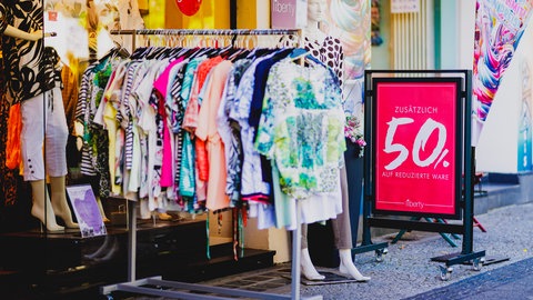 Kleiderständer voller billiger Klamotten verlocken die Menschen zum Kaufen