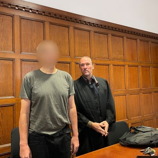 Der Angeklagte aus Eich (Gesicht verpixelt) steht mit seinem Verteidiger vor dem Mainzer Landgericht.