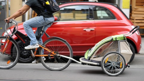 Ein Fahrrad mit Kinderanhänger - weil er nicht an ihm vorbeikam, hat in Mainz ein Autofahrer auf einen Radfahrer eingeschlagen (Symbolbild).