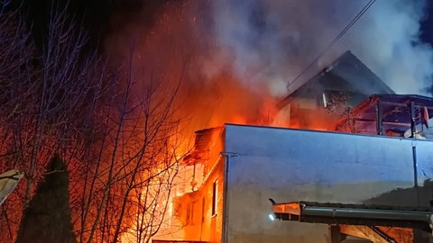 Flammen und Rauch kommen aus einem Wohnhaus: Das Feuer in Oberheimbach wurde gelegt. Das Mainzer Landgericht hat den Brandstifter zu einer Gefängnisstrafe verurteilt. 