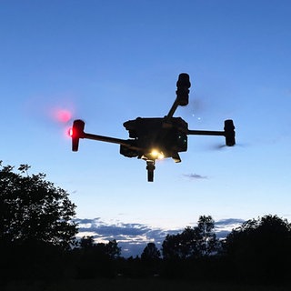 Eine Drohne steigt in den Nachthimmel auf. (Symbolbild)