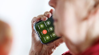 Eine Seniorin ist am Handy. In Mainz ist eine 70-Jährige Opfer von einem falschen PayPal Mitarbeiter geworden.